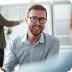 A businessperson smiles as they speak with a client.   